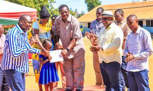 A child receives a birth certificate printed at the newly opened CRS office