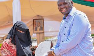 A Mother from the Pemba Community receives her child's Birth cerficate