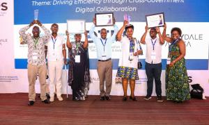 Director General of Immigration, Evelyn Cheluget, and team proudly raise their awards for Best Collaborative Digital Public Sector Initiative (ETA), State Department of the Year in Digital Innovation, and 1st Runner-Up in Overall Digital Transformation."